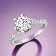 A silver solitaire ring with a large central cubic zirconia and smaller stones on the band.