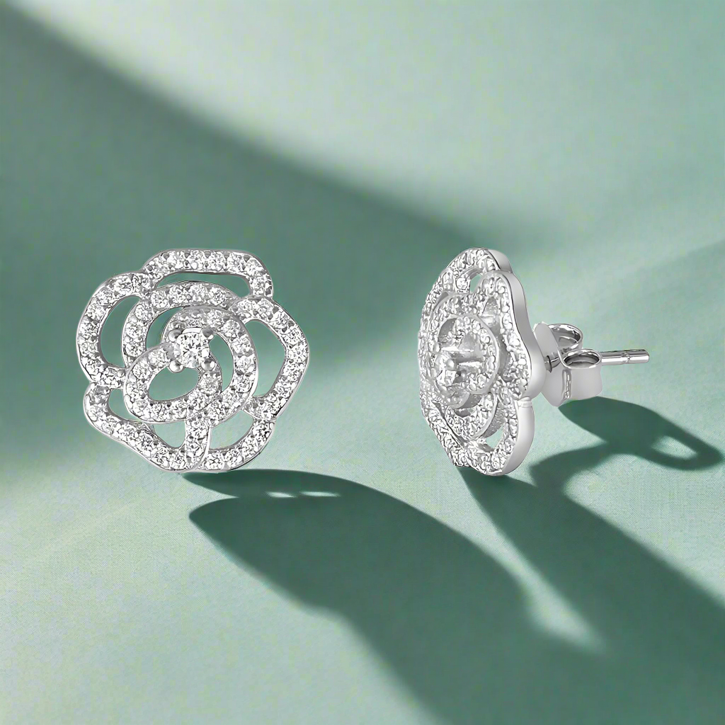 A pair of sterling silver stud earrings featuring a floral design with cubic zirconia accents.