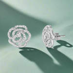 Load image into Gallery viewer, A pair of sterling silver stud earrings featuring a floral design with cubic zirconia accents.
