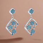 Load image into Gallery viewer, A pair of sterling silver earrings with blue firoza stones set in them, designed in a V-shape with a flowing pattern.
