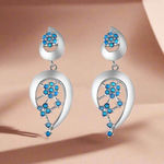 Load image into Gallery viewer, A pair of sterling silver earrings with blue firoza stone accents, designed in a chandelier style with floral patterns.
