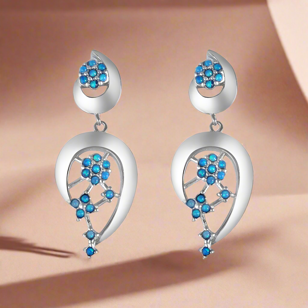 A pair of sterling silver earrings with blue firoza stone accents, designed in a chandelier style with floral patterns.