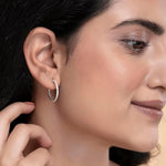 Load image into Gallery viewer, Close-up of a woman wearing a silver hoop earring.
