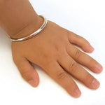 Load image into Gallery viewer, Hand wearing a silver bracelet on a white background
