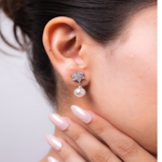 Load image into Gallery viewer, Close-up of an ear wearing a floral earring with a pearl drop, against a neutral background.

